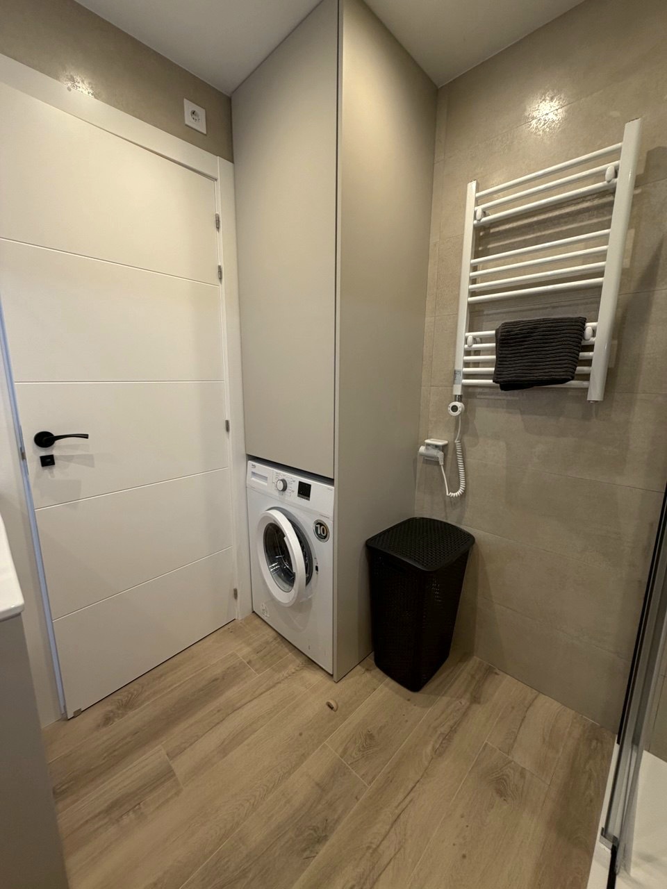 Utility area with washing machine and heated towel rail